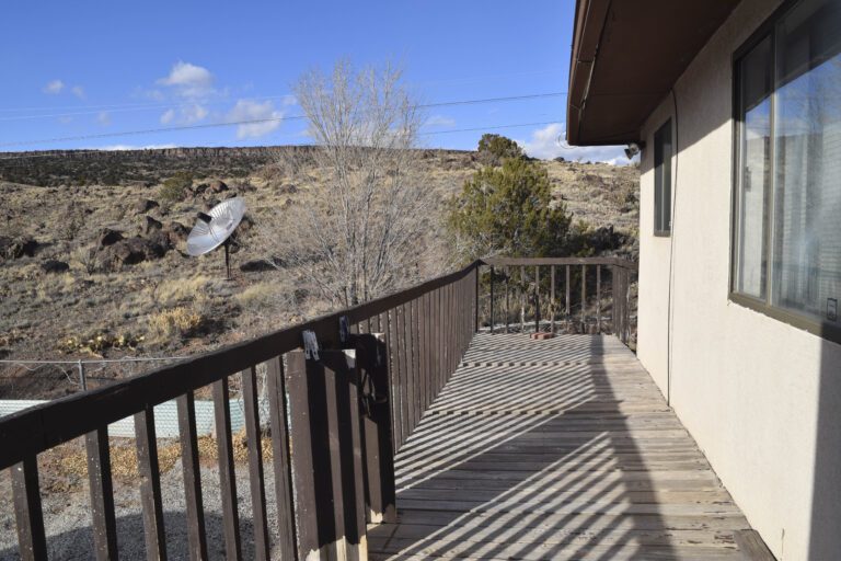 Exterior outside deck with brown railing to the left side.